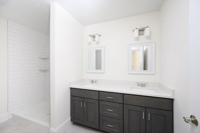 bathroom with tile flooring, double vanity, and tiled shower