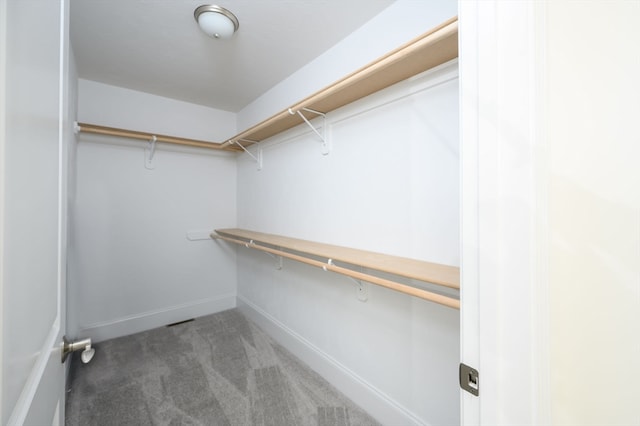 spacious closet featuring dark carpet