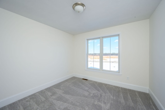 unfurnished room with dark colored carpet