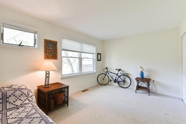 sitting room with carpet floors, baseboards, and visible vents