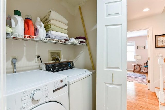 laundry room with washing machine and clothes dryer, laundry area, and light wood-style floors