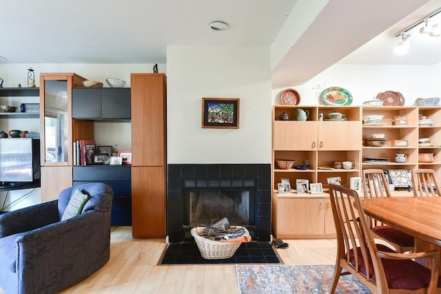 interior space with a tiled fireplace and light wood finished floors