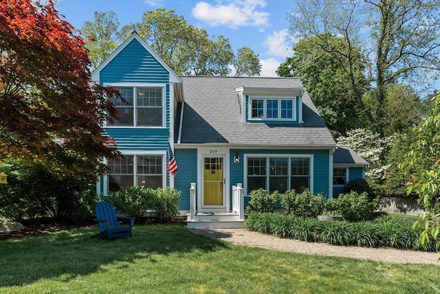 view of front of property with a front yard and roof with shingles