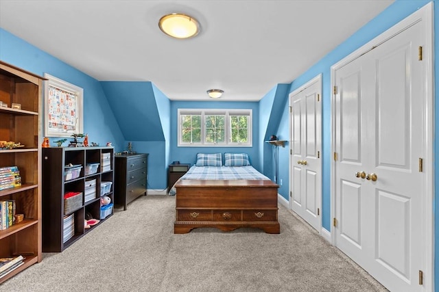 bedroom with carpet flooring, multiple closets, and baseboards