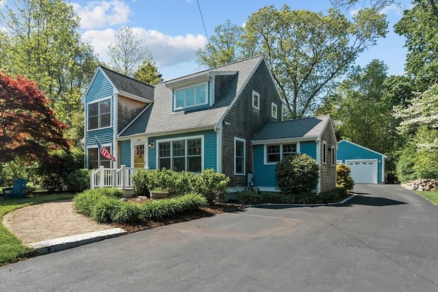view of front of property with a garage, an outdoor structure, and a shingled roof