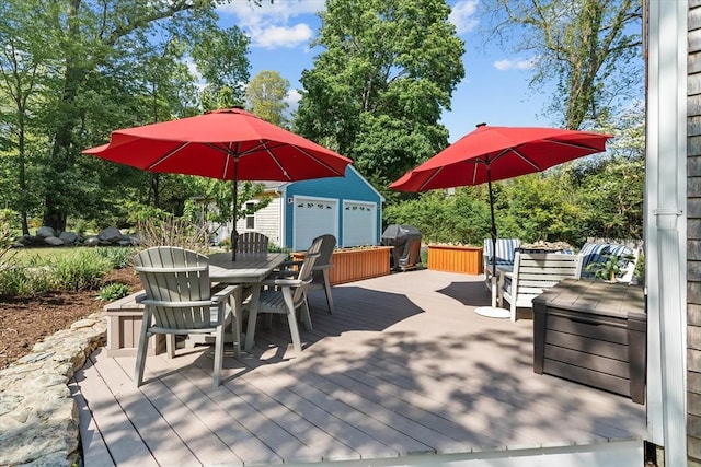 deck featuring outdoor dining space, an outbuilding, and a grill