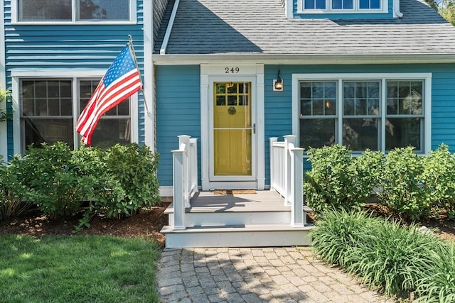 entrance to property with roof with shingles