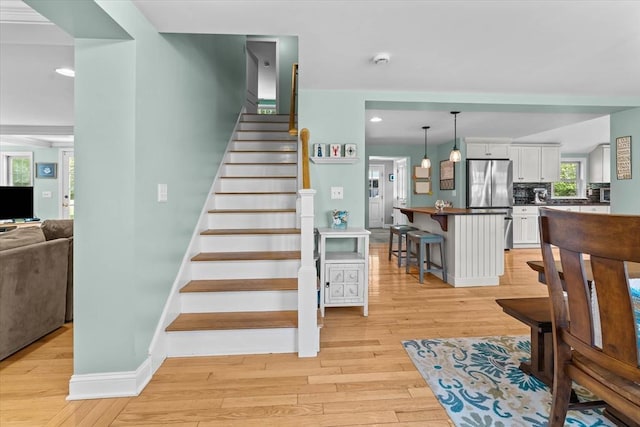 stairway featuring wood finished floors, recessed lighting, and baseboards