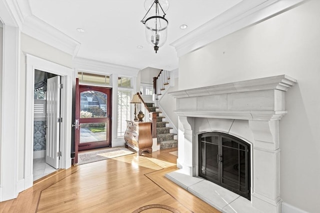 21 Circuit Ave, Scituate, MA 02066 - entrance foyer featuring a fireplace with raised hearth, stairway, ornamental molding, wood finished floors, and baseboards