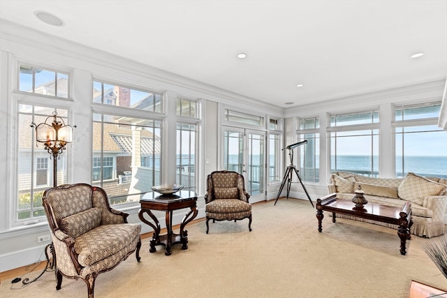 sunroom featuring a water view, a healthy amount of sunlight, and a notable chandelier