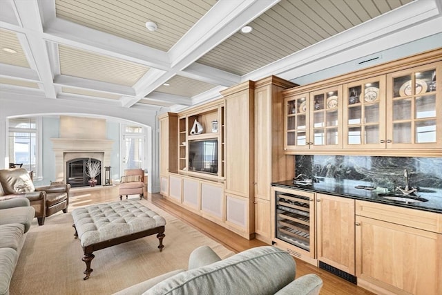 21 Circuit Ave, Scituate, MA 02066 - living area featuring beverage cooler, light wood-type flooring, beamed ceiling, wet bar, and arched walkways