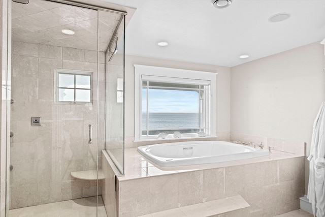 bathroom with tile patterned flooring, a water view, plenty of natural light, and independent shower and bath