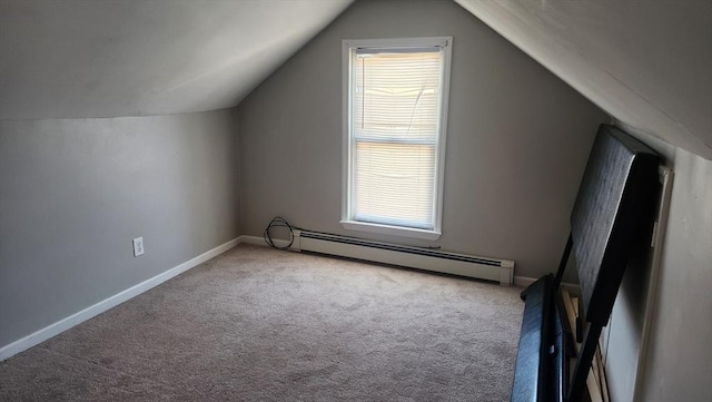 additional living space with baseboard heating, carpet, vaulted ceiling, and a healthy amount of sunlight