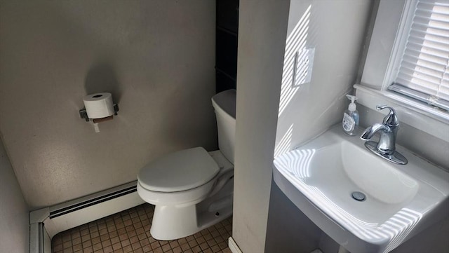 half bath featuring a baseboard radiator, toilet, and a sink