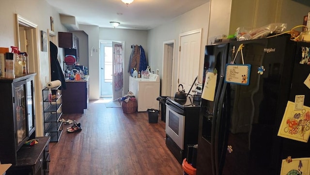 interior space featuring washer and clothes dryer, stainless steel range with electric stovetop, dark wood-style floors, and black fridge