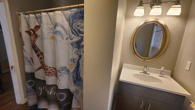 full bath with a shower with curtain, vanity, and wood finished floors