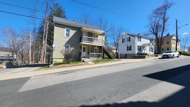 view of front of home featuring stairway, a balcony, and covered porch