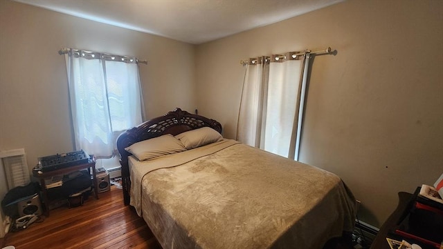 bedroom with a baseboard radiator and dark wood-type flooring