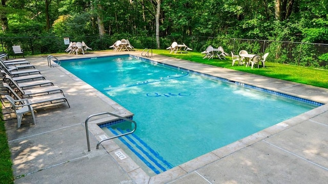 community pool featuring a patio, a yard, a fenced backyard, and playground community