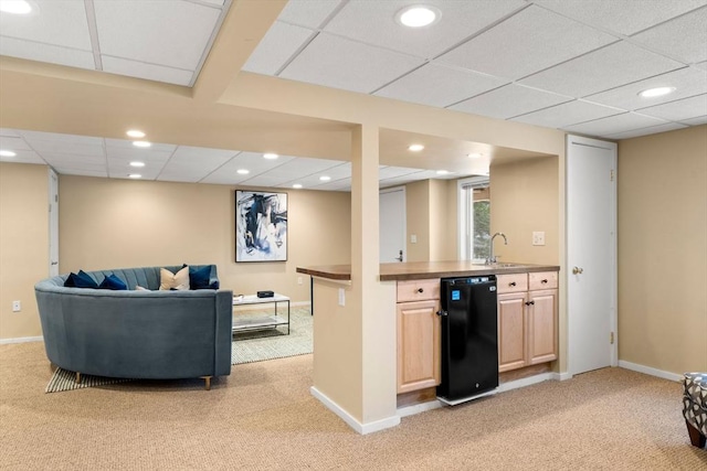 interior space with light brown cabinets, a drop ceiling, refrigerator, open floor plan, and recessed lighting