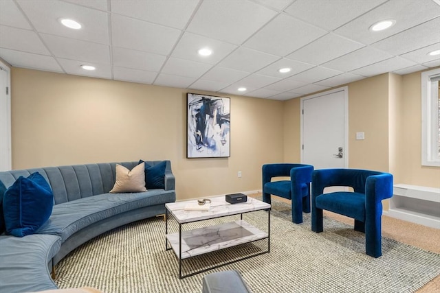 carpeted living room with a drop ceiling, recessed lighting, and baseboards