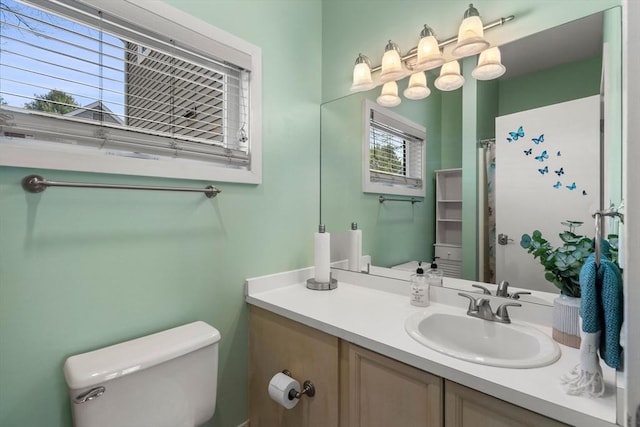 bathroom featuring toilet, vanity, and a shower with curtain