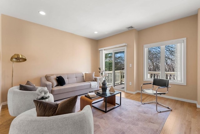 living area featuring recessed lighting, light wood-style floors, visible vents, and baseboards