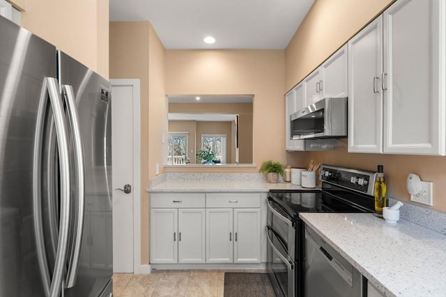 kitchen with recessed lighting, white cabinets, stainless steel appliances, and light stone countertops