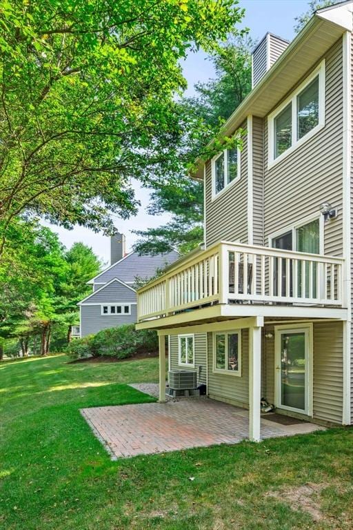 back of house with a patio, a yard, cooling unit, and a chimney