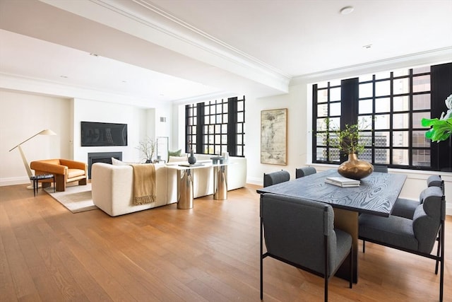 dining area with ornamental molding and light wood-type flooring