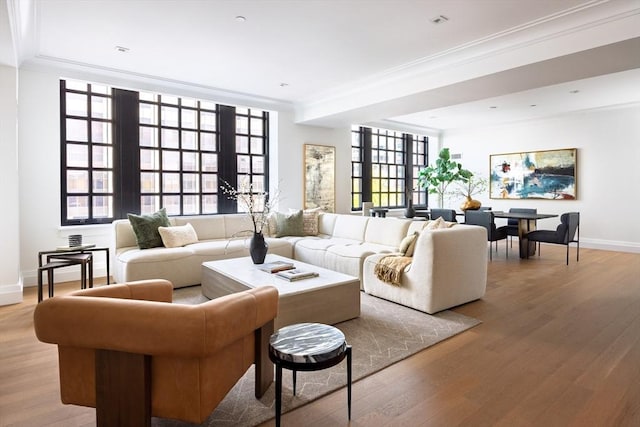 living room with light wood-type flooring and ornamental molding