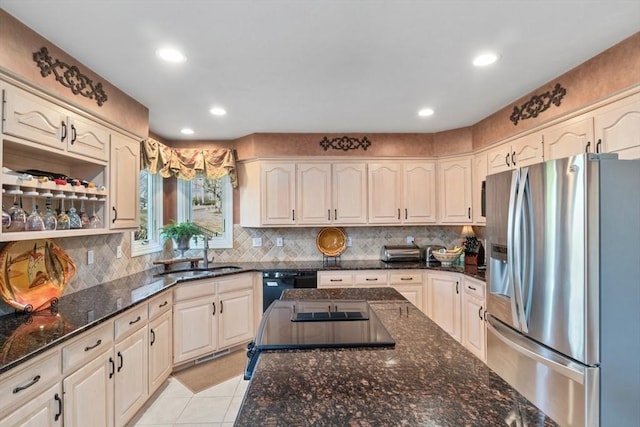 kitchen featuring a sink, black dishwasher, dark stone counters, stainless steel fridge with ice dispenser, and light tile patterned floors