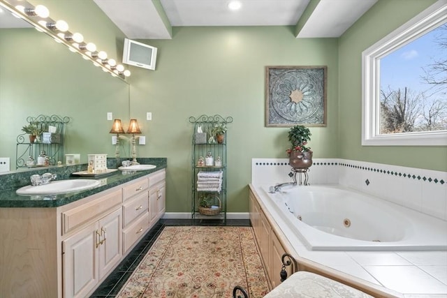 bathroom featuring tile patterned flooring, a jetted tub, baseboards, double vanity, and a sink