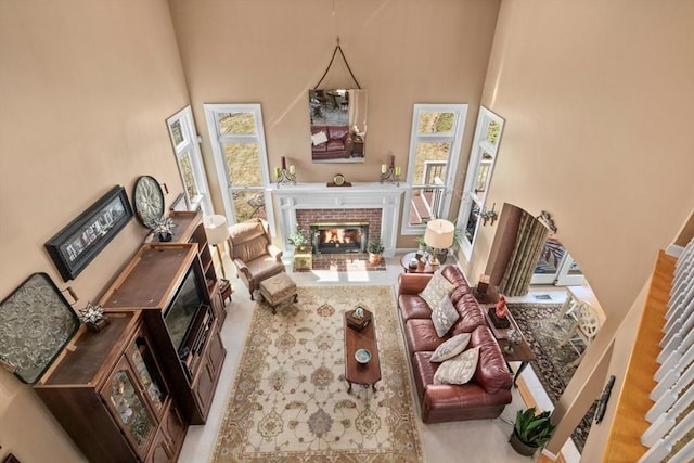 living room with a brick fireplace and a high ceiling