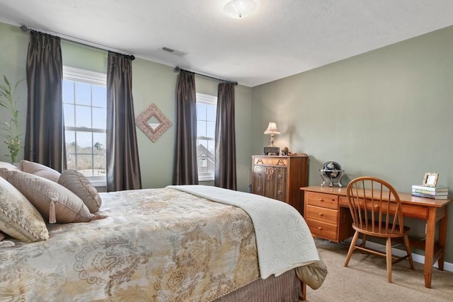 carpeted bedroom with visible vents and multiple windows