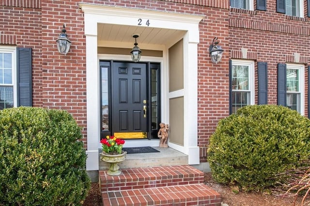 view of exterior entry featuring brick siding