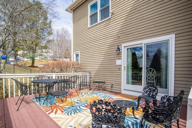 wooden terrace with outdoor dining space and fence