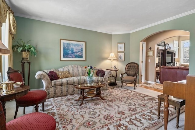 living room featuring arched walkways, crown molding, and baseboards