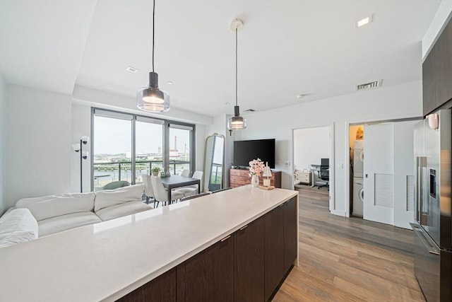 375 Canal St Unit 1109, Somerville, MA 02145 - kitchen with open floor plan, stacked washing machine and dryer, light countertops, and high quality fridge