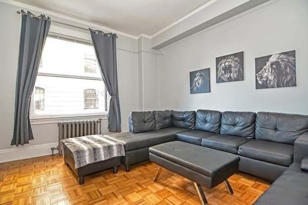 living room featuring crown molding, radiator heating unit, and light parquet flooring