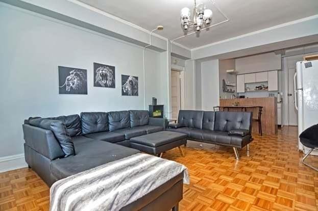 living room featuring light parquet floors, crown molding, and a chandelier