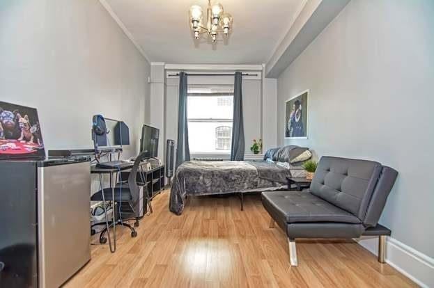 bedroom featuring crown molding, a chandelier, and light wood-type flooring