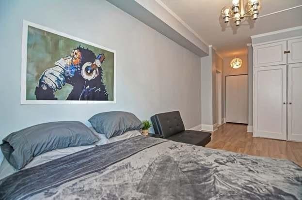 bedroom featuring a closet, a chandelier, and light hardwood / wood-style flooring