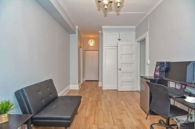 office space featuring crown molding, an inviting chandelier, and light hardwood / wood-style flooring