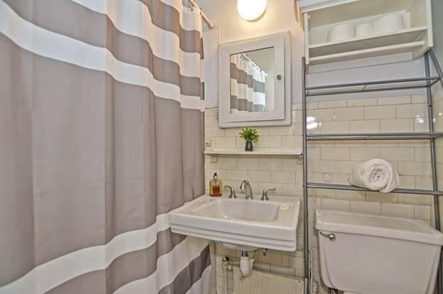 bathroom with toilet, sink, tile walls, and decorative backsplash