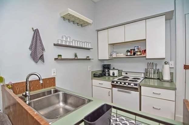 kitchen featuring white cabinetry, sink, and white range with electric cooktop