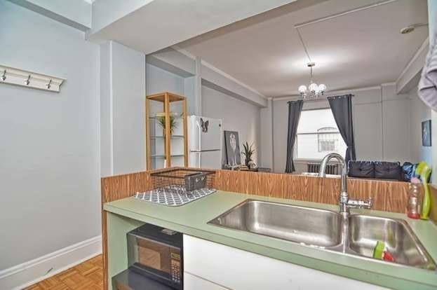 kitchen with parquet floors, sink, a chandelier, and white fridge