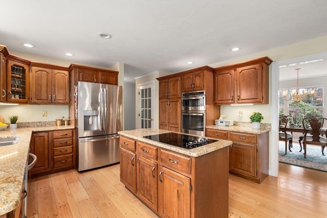 14 Frost Ln, Sudbury, MA 01776 - kitchen featuring stainless steel appliances, light wood finished floors, a center island, light stone countertops, and recessed lighting