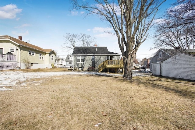 back of house with a lawn and a wooden deck