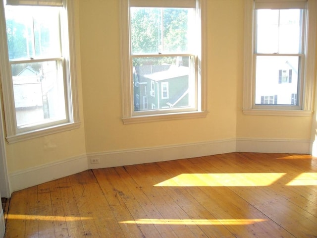 unfurnished room featuring hardwood / wood-style floors and baseboards